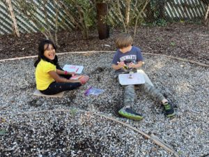 Boy and girl doing math in the garden