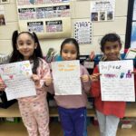 Three girls sharing their writing pieces