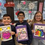 Two boys and a girl with heart cards