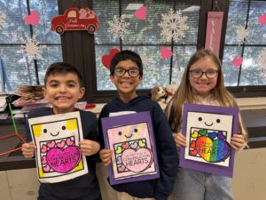 Two boys and a girl with heart cards