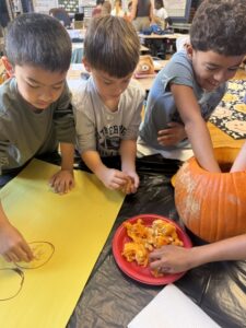 student scooping out pumpkin seeds