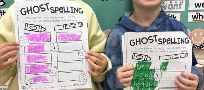 girl and boy showing their spelling pages
